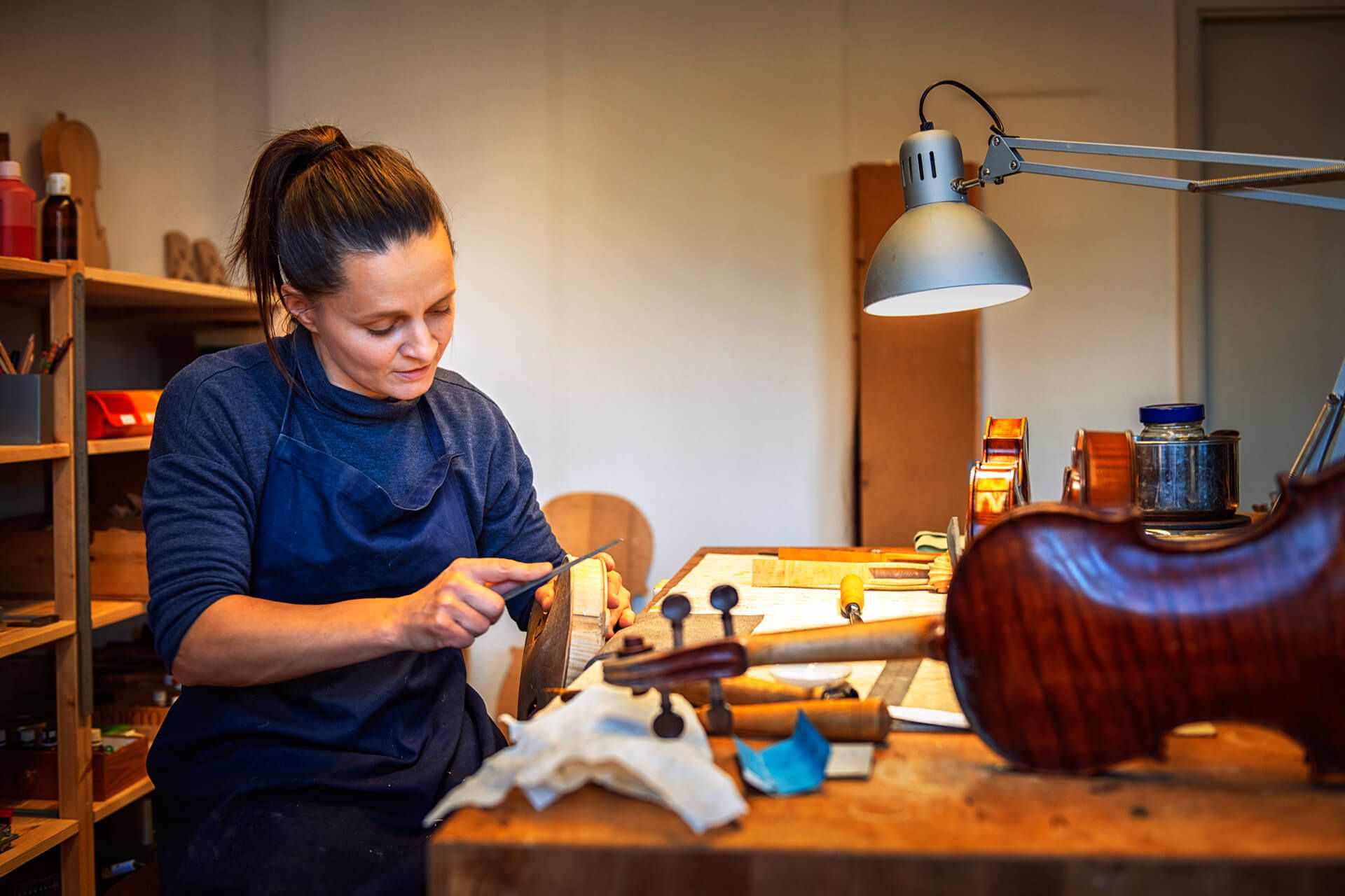 Judith Bauer feilt die Ränder einer Geige ab.