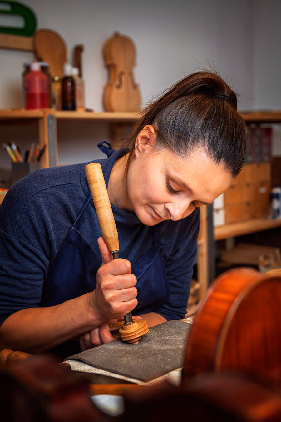 Judith Bauer schnitzt den Griff einer Geige.